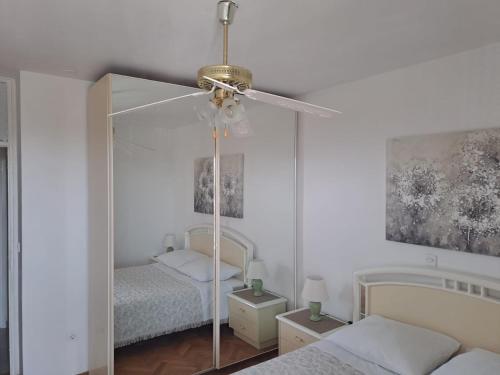 a bedroom with two beds and a ceiling fan at City, sea and river view, Omis in Omiš