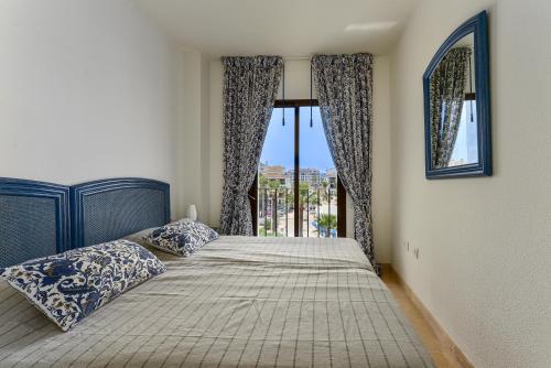 1 dormitorio con cama y ventana grande en Duquesa Port retreat en Manilva