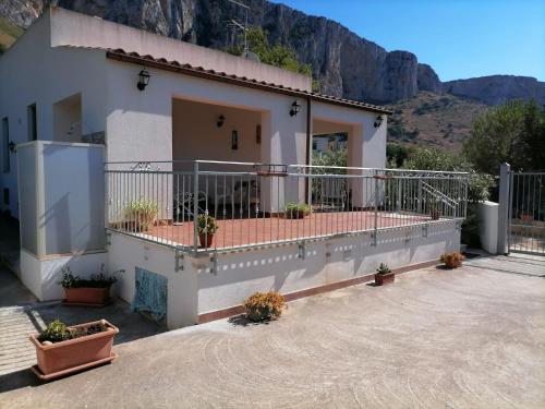 ein Haus mit einem Balkon mit einem Berg im Hintergrund in der Unterkunft La casa di Agata in San Vito lo Capo