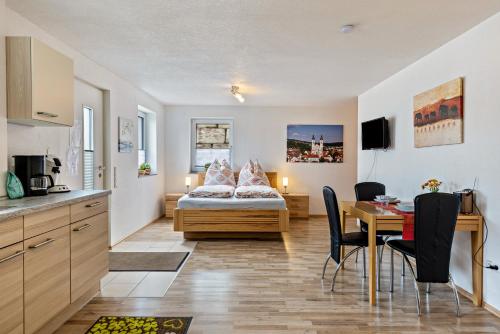 eine Küche und ein Wohnzimmer mit einem Bett und einem Tisch in der Unterkunft Ferienwohnung Alpenblick in Zwiefalten