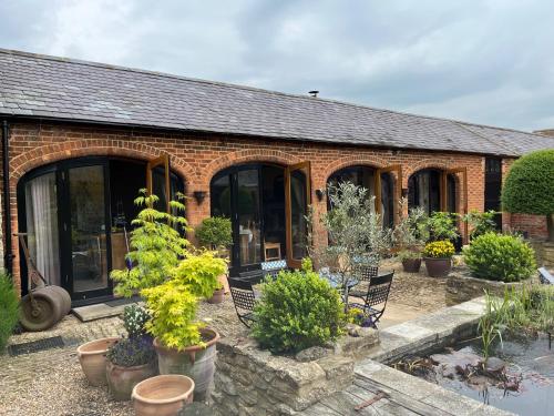 a brick house with plants in front of it at The Arches - Private woods, comfy beds, fast Wi-Fi, SkyNetflix in Wellingborough