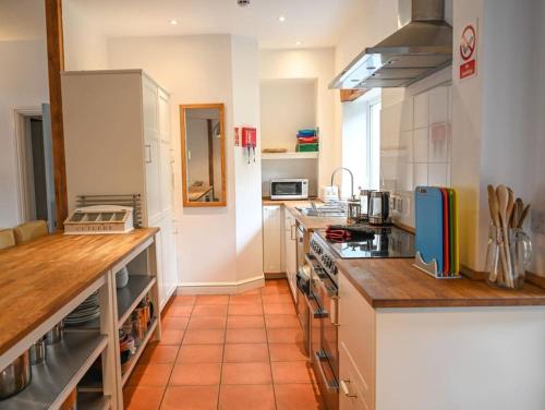 uma cozinha com armários brancos e uma bancada em The Allendale Bunkhouse em Hexham