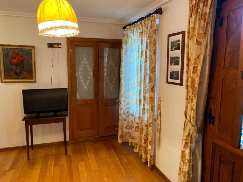 een kamer met een deur en een televisie en een lamp bij Casa Benaxo in Currelos