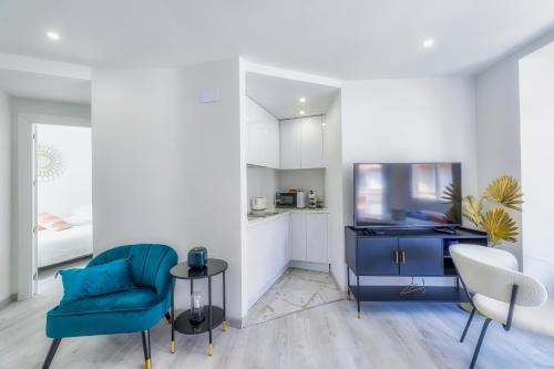a living room with a blue chair and a sink at Playa Del Cura Apartment in Torrevieja
