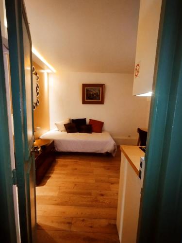 een slaapkamer met een bed met een witte sprei en houten vloeren bij Sacré coeur studio in Parijs