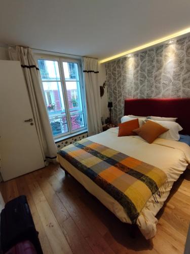 une chambre avec un grand lit et une fenêtre dans l'établissement Sacré coeur studio, à Paris