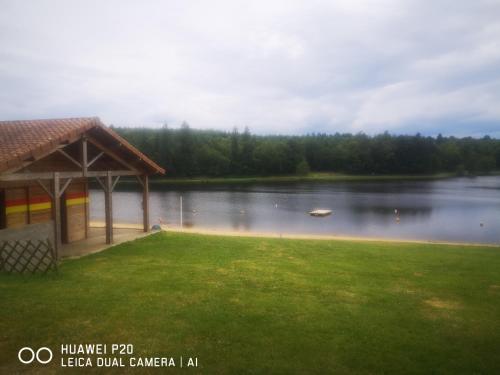 a gazebo next to a lake with a boat at Belle Vue Gite in Saint-Mathieu