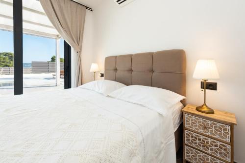 a bedroom with a large bed and a large window at Beach Haven house with pool in Kaštela