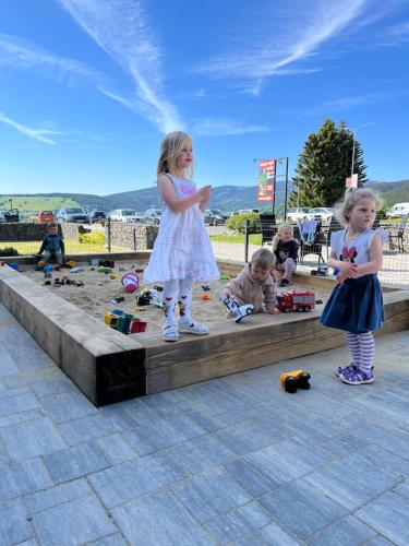 two little girls are playing in the sand at Apartmány Family aréna in Benecko