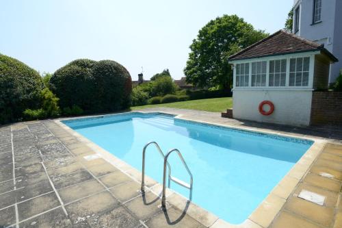 a swimming pool in a yard with a house at West Dean College in West Dean
