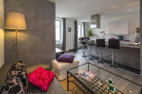 un salon avec un canapé et une cuisine dans l'établissement Les Loges du Chateau, à Saverne