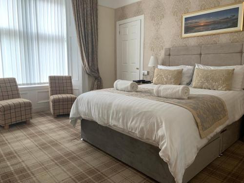 a bedroom with a large bed and a chair at Sandvilla Guesthouse in Oban