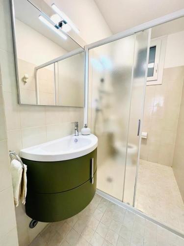 a bathroom with a green sink and a shower at ANTONELLA PLUS in Bibione