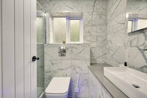 Little BursteadにあるLuxurious quiet 5-bedroom house.のトイレと洗面台を備えた白いバスルーム