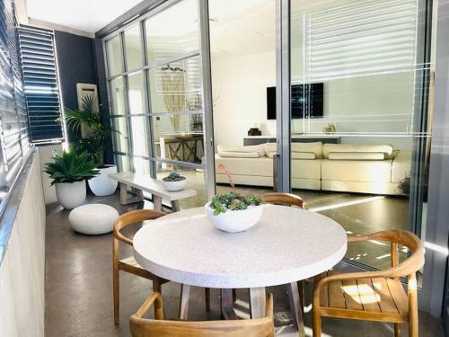 a room with a table and chairs and a couch at KozyGuru / Botany / 3 Bedroom Designer Apt / NBO003 in Sydney