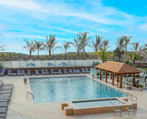 - une piscine dans un complexe avec des chaises et des palmiers dans l'établissement Holiday Inn Ocean City, an IHG Hotel, à Ocean City