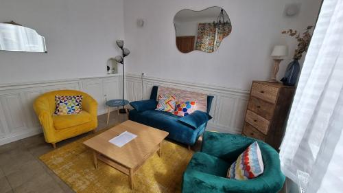a living room with two chairs and a blue couch at Maison du quai à Saint Valéry sur Somme in Saint-Valery-sur-Somme