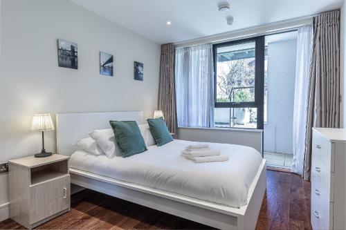 1 dormitorio con 1 cama blanca y ventana en 3 Bedrooms Close to Canning Town & ExCel London en Londres