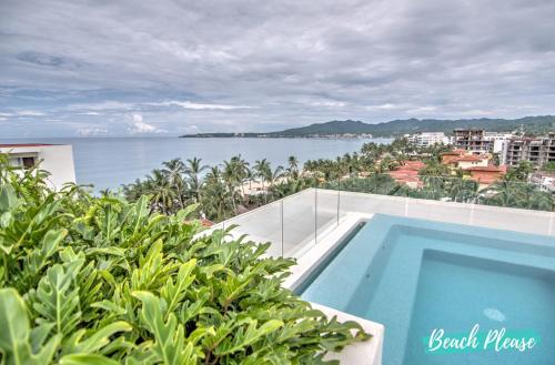 a swimming pool on top of a building with a view of the water at Pavilion 2BR Golden Zone - 1 Block to Beach in Bucerías