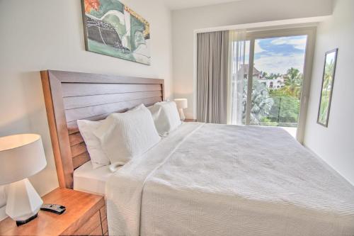 a white bedroom with a large bed and a window at Pavilion 2BR Golden Zone - 1 Block to Beach in Bucerías