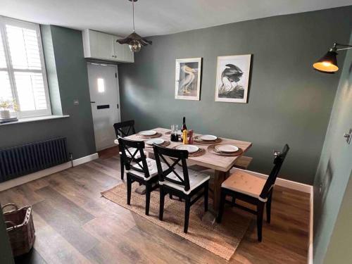 a dining room with a wooden table and chairs at Cosy Lake District Cottage in Staveley