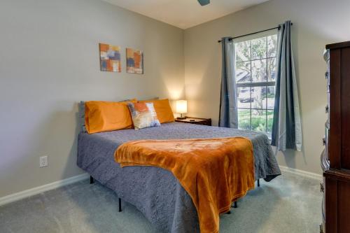 a bedroom with a bed with an orange blanket on it at Clermont Vacation Rental with Community Pool! in Clermont