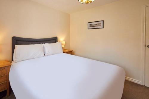 Un dormitorio con una gran cama blanca y una mesa en Host & Stay - Pearl Street, en Saltburn-by-the-Sea