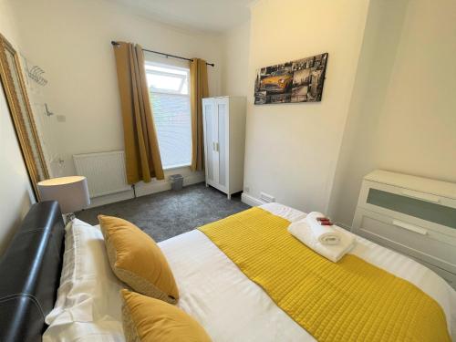 a bedroom with a bed with a yellow blanket on it at Robinhuts - 3 Bed Accommodation -Perfect for Contractors, Families & Students in Hull