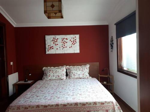 a bedroom with a bed with a red wall at Apartamento tranquilo en una casa con jardín in Las Lagunas