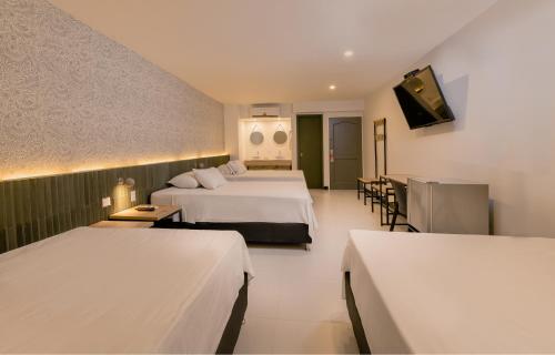 um quarto de hotel com duas camas e uma televisão em Hotel Principe em Tuluá