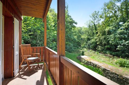 a porch with a chair and a view of the woods at Gutenburghüsli mit Garten am Fluss in Waldshut-Tiengen