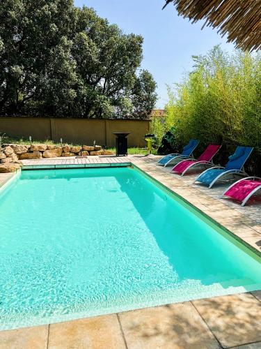 einen Pool mit blauen und rosa Liegestühlen in der Unterkunft Le gite de Dylan in Valréas