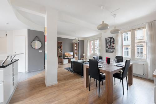 une salle à manger et un salon avec une table et des chaises dans l'établissement T3 Hyper Centre - Spacieux et Confortable, à Toulouse