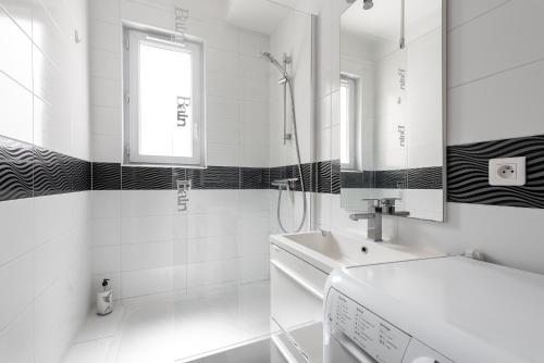 une salle de bain blanche avec un lavabo et un miroir dans l'établissement T3 Hyper Centre - Spacieux et Confortable, à Toulouse