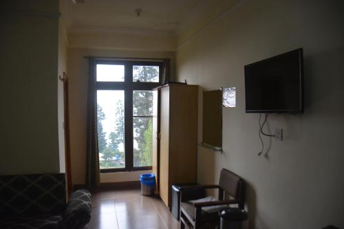 een woonkamer met een tv en een raam bij Eagle Nest, Malam Jabba by LMC in Swat