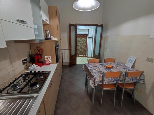 eine Küche mit einem Tisch und eine Küche mit einem Herd in der Unterkunft Coccole Apartment in La Spezia