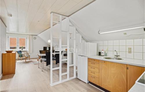 1 Bedroom Cozy Apartment In Ringkbing في رينكوبنج: مطبخ مع أجهزة بيضاء وغرفة طعام