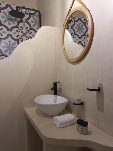 a bathroom with a bowl sink and a mirror at Valia's Beach House in Samos