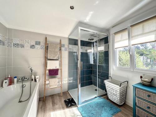 Das Bad ist mit einer Dusche, einer Badewanne und einer Dusche ausgestattet. in der Unterkunft Villa Nolaene, 8-9 pers, Piscine, Calme et Moderne in Gujan-Mestras