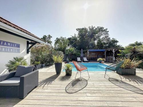 twee stoelen op een terras naast een zwembad bij Villa Nolaene, 8-9 pers, Piscine, Calme et Moderne in Gujan-Mestras