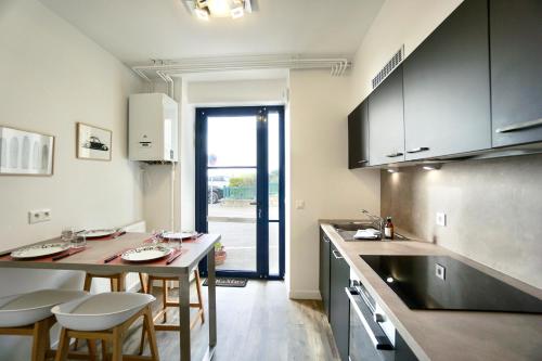 une cuisine avec une table et quelques chaises dans l'établissement La cale * Front de Mer*, à Ploemeur