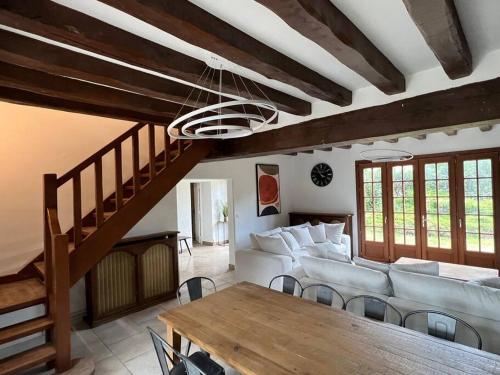 a living room with a couch and a table at La clé des champs - Les Grais 1H10 de Paris in Bazoches-sur-le-Betz