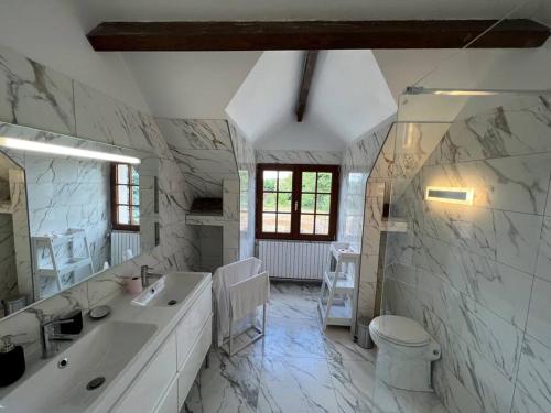 a white bathroom with a sink and a toilet at La clé des champs - Les Grais 1H10 de Paris in Bazoches-sur-le-Betz