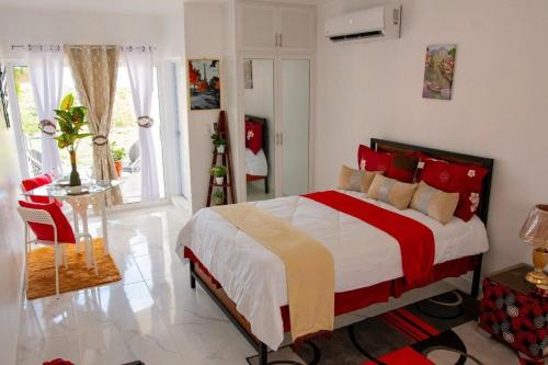 a bedroom with a large bed with red pillows at Royal Terrace I (Queen ) in San Felipe de Puerto Plata