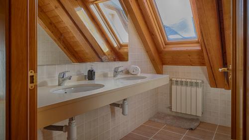 a bathroom with two sinks and a mirror at Saplan Real Estate LAUJÒ in Bossost