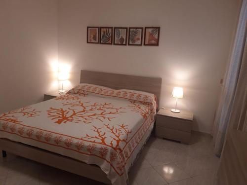 - une chambre avec un lit et deux lampes sur deux tables dans l'établissement Appartamento In Riva Al Mare con Posto Auto E Disponibilità Bicicletta, à Mascali