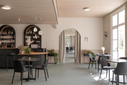 restauracja ze stołami i krzesłami oraz bar w obiekcie Hôtel Le Prieuré w mieście Paray-le-Monial