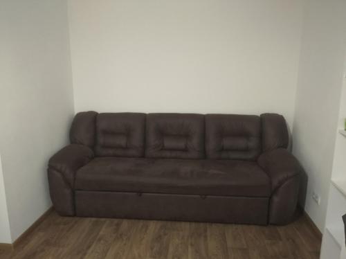 a brown couch in a corner of a room at Апартамент в Новобудові Стрийська Автовокзал in Lviv