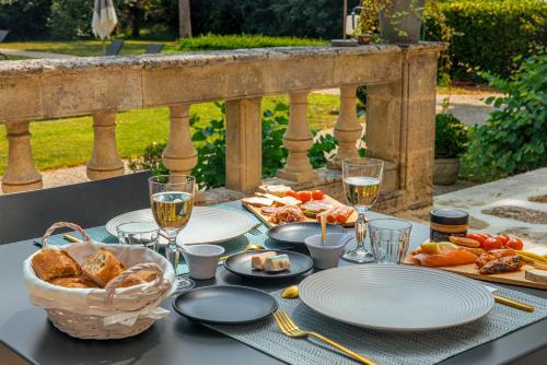 a table with plates of food and a basket of bread at Clos Marcamps - Teritoria in Prignac-et-Marcamps