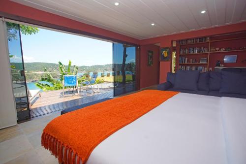 a bedroom with a large bed and a large window at Cliffside Luxury Inn in Búzios
